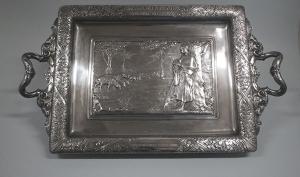 Plateau à anses en métal argenté, décoré par un relief représentant une bergère avec son troupeau de moutons. 