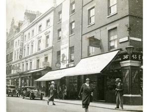 Vue de Londres, datée de 1934 : une rue animée avec voitures et personnages. Photographie rapportée de Londres par Pierre Mac Orlan à l'occasion d'un de ses reportages.