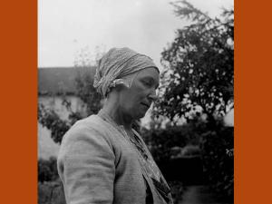 Photographie d'une femme coiffée d'un carré de coton gris noué sur la chevelure, communément appelé marmotte.