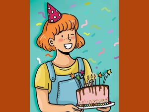 Une petite fille souriante tien gâteau d'anniversaire devant elle