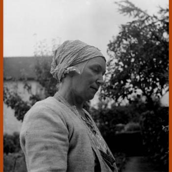 Photographie d'une femme coiffée d'un carré de coton gris noué sur la chevelure, communément appelé marmotte.
