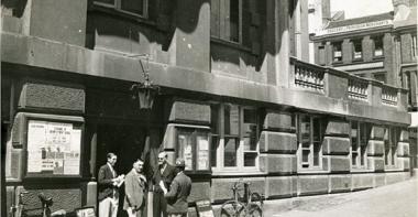 Vue de Londres, datée de 1934 : groupe d'hommes à l'entrée d'un bâtiment administratif. Photographie rapportée de Londres par Pierre Mac Orlan à l'occasion d'un de ses reportages.